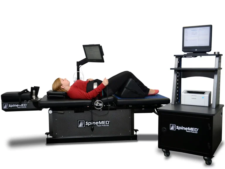Paciente recibiendo tratamiento con máquina SpineMED® de descompresión vertebral axial en clínica especializada