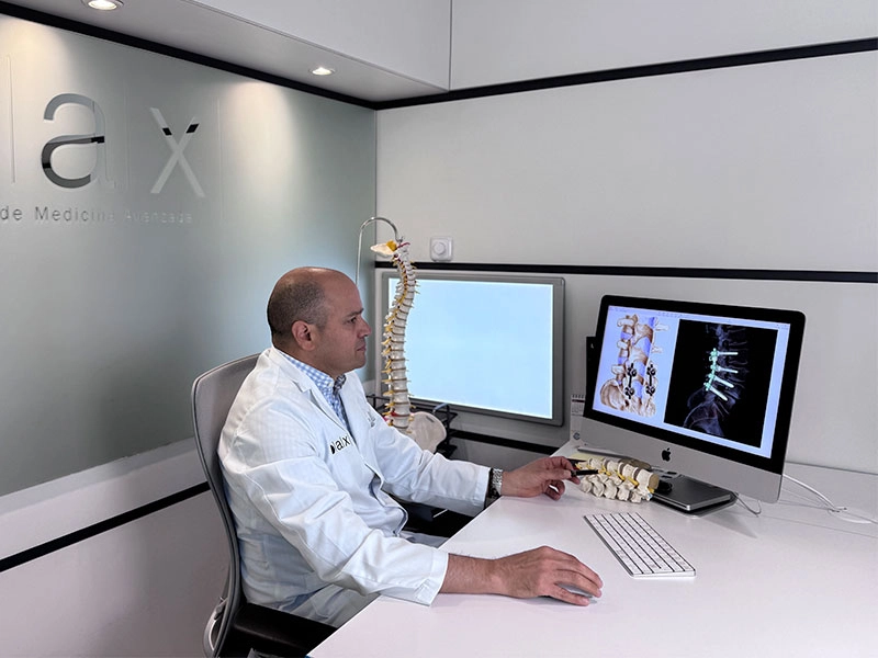 Médico especializado en columna diseñando tratamiento no quirúrgico a partir de diagnóstico por imagen para evitar operaciones innecesarias.